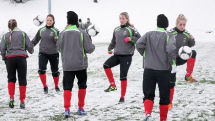 Moterys išeina į stadioną