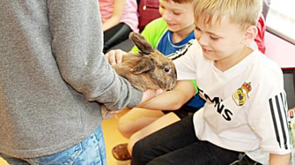 Bibliotekoje vaikai skaito kartu su gyvūnais
