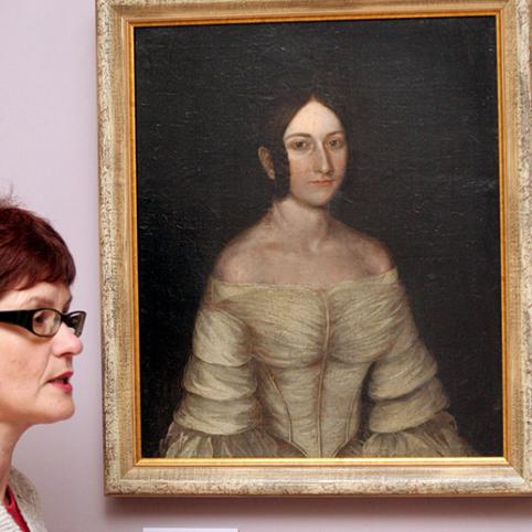 Ch. Fren­ke­lio vi­lo­je eks­po­nuo­ja­mas pa­veiks­las tik iš pir­mo žvilgs­nio at­ro­do įpras­tai: po ne­ži­no­mos mo­ters Olim­pi­jos Reo­no­ros po­rtre­to da­žų sluoks­niu sly­pi ki­tos mo­ters po­rtre­tas.